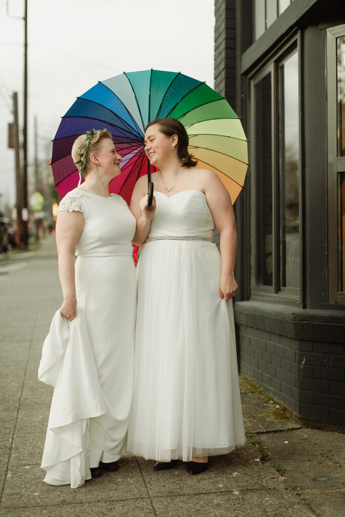 picture of two women holding rainbow umbrella